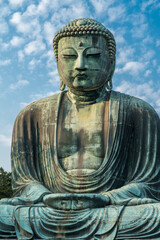 The Great Buddha or Daibutsu at Kotoku-in Buddhist Temple. A large bronze statue found in Kamakura, Japan. Photographed with a bright blue sky.