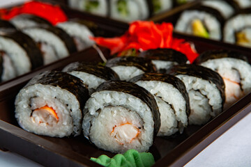 Japanese food rolls in plastic box. Sushi set in a plastic package close up isolated on a white background. Sushi for take away or sushi delivery.