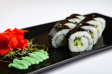 Japanese food rolls in plastic box. Sushi set in a plastic package close up isolated on a white background. Sushi for take away or sushi delivery.