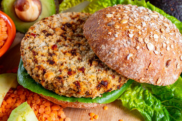 Tasty vegetarian healthy food, homemade burgers made from orange lentils legumes with green lettuce and fresh ripe avocado