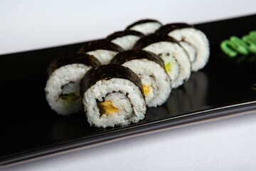Japanese food rolls in plastic box. Sushi set in a plastic package close up isolated on a white background. Sushi for take away or sushi delivery.