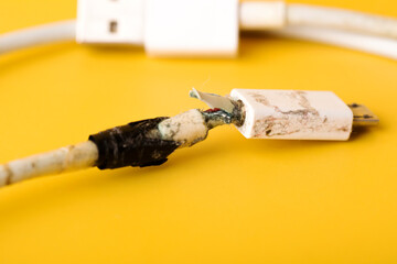 Broken micro USB phone charging cable. Damaged white usb cable plug bandaged by duct tape.