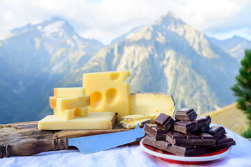 Tasty Swiss cheeses and dark pure chocolate, emmental, gruyere, appenzeller served outdoor with...