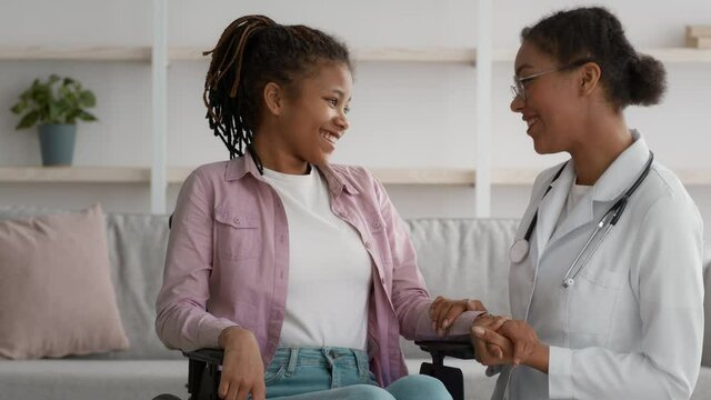 Happy Handicapped Black Girl And Doctor Talking About Recovery Indoor