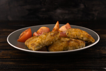 Juicy breaded pork meat with tomato slices