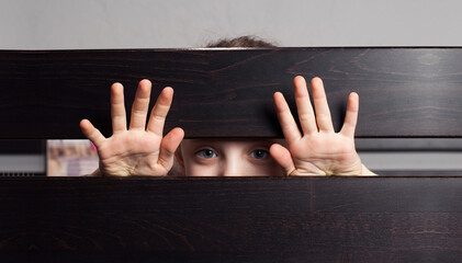 Child's hands. The child looks through the crack. In the bed. Violence and loneliness concept