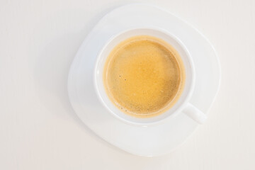 Close up top view of a white porcelain cup of coffee isolated on white background