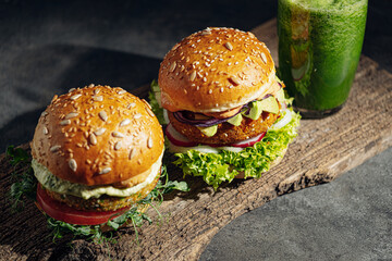 two bright fresh veggie burger without gluten and meat. burger on a gray stone background. serving...