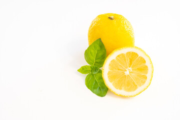 Whole yellow lemon fruit with half lemon isolated on white background with leaf and copy space