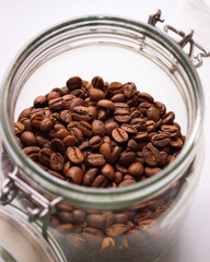 Aroma coffee beans in a glass jar on a white background