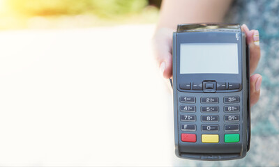 Close-up female hand using swiping machine to pay credit card. Private businessman and cashless...