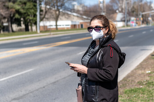 Latin American Woman Waiting For An Uber In An Empty Toronto Street During The Coronavirus Pandemic, Canada