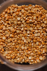 Yellow split peas in glass jar on black backroung