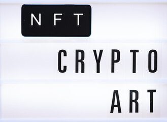 NFT crypto art inscriptions on mobile screen and white  background. Close-up, top view, copy space.