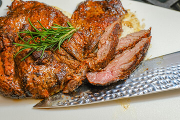 Marinated steak sliced in pieces with cilantro in a cutting board