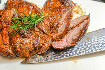 Marinated steak sliced in pieces with cilantro in a cutting board