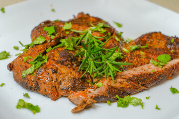 Marinated steak sliced in pieces with cilantro in a cutting board