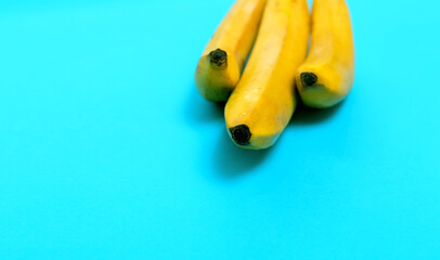 Three yellow bananas. Group of bananas on blue background.