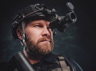 Modern soldier looks in night vision device inbuilt in his helmet