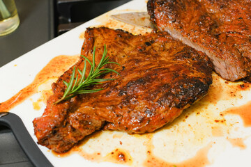 Marinated steak sliced in pieces with cilantro in a cutting board