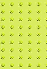 Vertical pattern of a whole green apple on a green background.