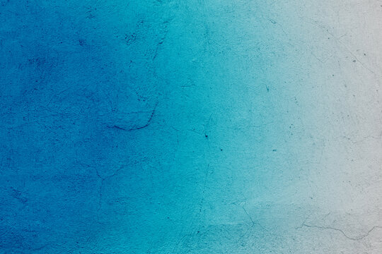 Delicate blue and white texture of a wall with a crack in Paris. Delicate blue background or texture