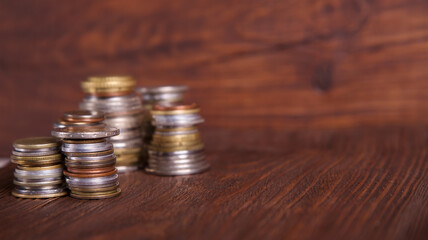 Coins on the background of mahogany. Stacks of coins of different nominal value. Concept - advertising about the bank or finances company.