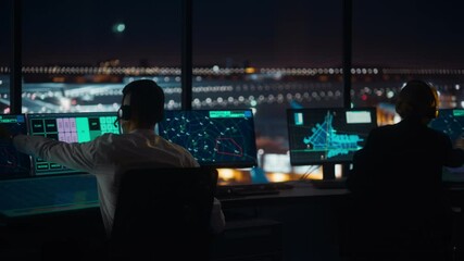 Diverse Air Traffic Control Team Working in a Modern Airport Tower at Night. Office Room is Full of Desktop Computer Displays with Navigation Screens, Airplane Flight Radar Data for Controllers.