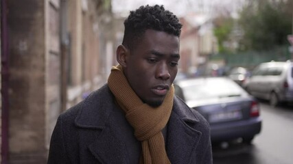 Upset black man walking in city. Angry frustrated person emotion