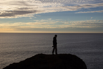 Fototapeta premium person walking on the beach at sunset