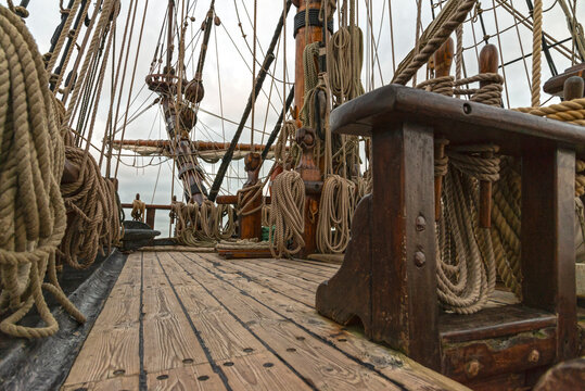cubierta de un barco velero en el que se ven las cuerdas , m&aacute;stil y dem&aacute;s componentes .