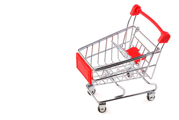 Empty grocery shopping cart. Miniature empty red color shopping cart or trolley isolated on white background. There is some free space for your text or sign.