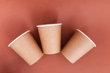 three paper cups on brown background, ecology concept
