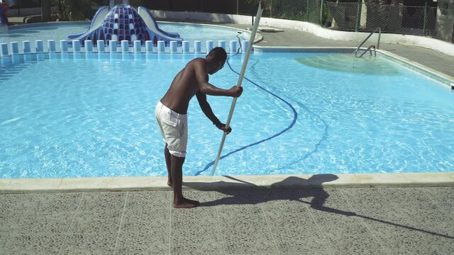 Cairo, Egypt - 15 September, 2019: Hand african hotel staff worker cleaning the pool