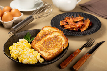 Breakfast. Scrambled egg with toast and bacon.