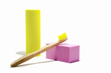 Eco-friendly wooden toothbrush with natural yellow bristles. Abstract composition with podium and...