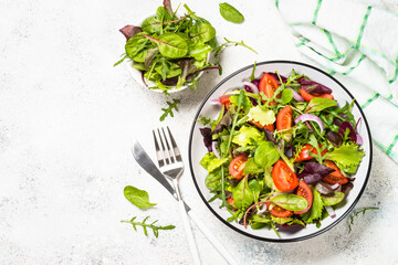 Green salad with fresh vegetables at white.