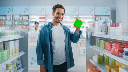 Pharmacy Drugstore: Portrait of Handsome Latin Man Holding Mock-up Template Medicine Package with Tracking Markers, Looking at Camera, Smiling Happily. Customer Recommending Best Product