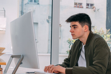 Fototapeta premium teenage boy working with computer at home