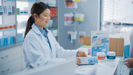 Pharmacy Drugstore Checkout Cashier Counter: Professional Asian Female Pharmacist Recommends Medicine in a Package, Caucasian Female Customer Pays for It.
