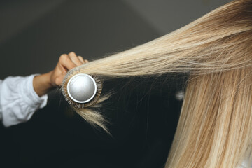 Fototapeta premium Hairdresser straightening client's dyed hair