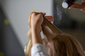 Stylist's hand applying volume hair powder