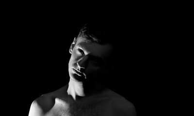 Fototapeta na wymiar black and white photo portrait of a guy, in dramatic lighting