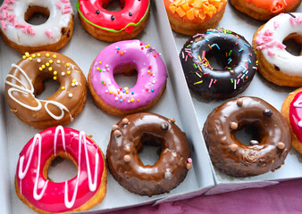 Delicious colorful donuts with different flavors and interesting decorations on the background