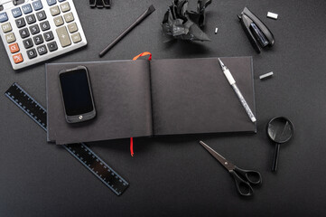 Black bookkeeping. Black office. Black stationery on the table. View from above. Top.