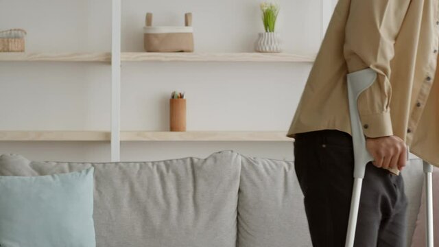 Side-View Of Unrecognizable Guy Walking With Crutches At Home, Cropped