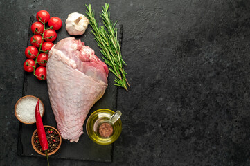 raw turkey leg with rosemary on stone background with copy space for your text