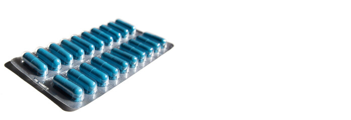 tablets in a soluble blue capsule. transparent packaging of medicines on a white background. soft focus