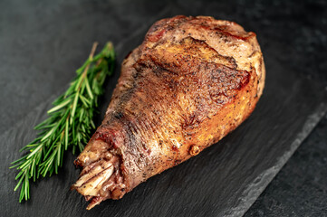 Baked turkey, turkey leg with rosemary on a stone background 