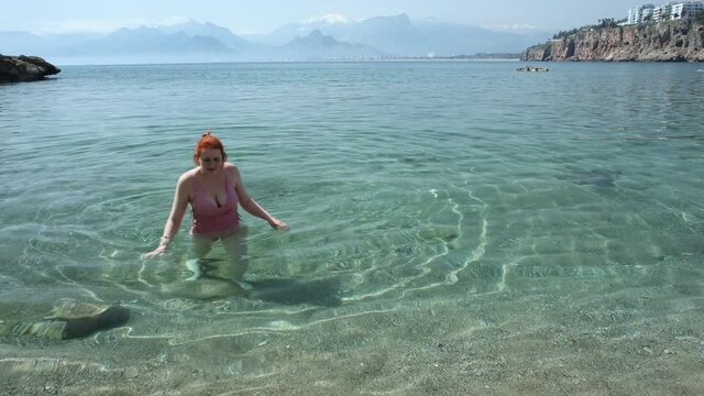 A short swim in the cold sea water in early spring in Antalya, a young white woman quickly came ashore.